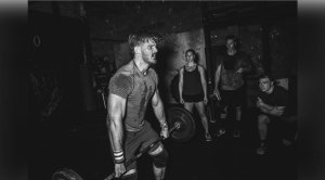 CrossFitters watching man lift barbell