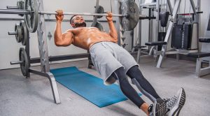 Muscular man performing and demonstrating Inverted Row mistakes and fixes