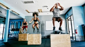 Group fitness class working out with box jumps exercises and Plyometric exercises