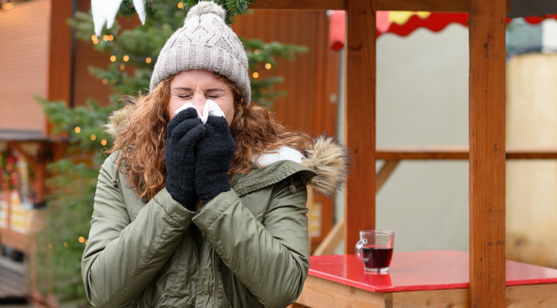 Woman sneezing in cold weather