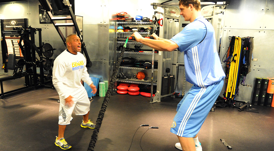 Strength and conditioning coach Steve Hess works with Timofey Mozgov #25 of the Denver Nuggets during the first day of training camp on December 9, 2011 at the Pepsi Center in Denver, Colorado.