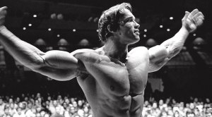 Arnold Shwazenegar in front of a crowded Olympia event