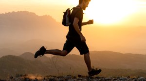 Fit man running on an outdoor trail wearing men's running gear