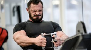 Muscular bearded man performing healthy aging practices with exercises