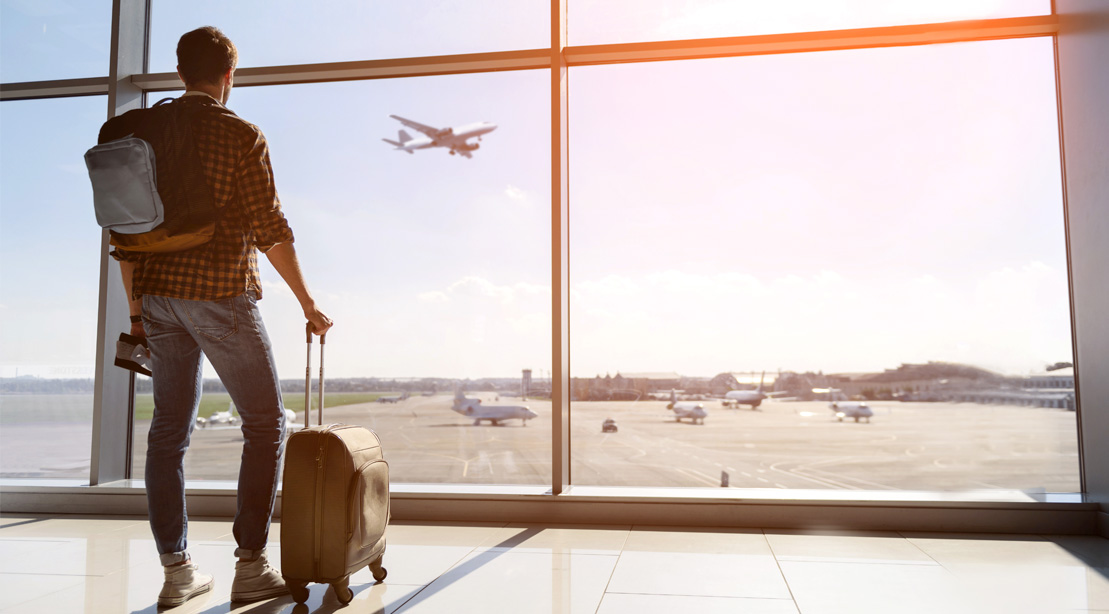 Young-Man-At-Airport-Baggage-Looking-At-Airplane