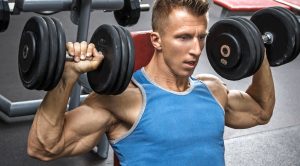 Fit male performing a seated dumbbell press exercises as part of his time-saving training methods dumbbell workout complex