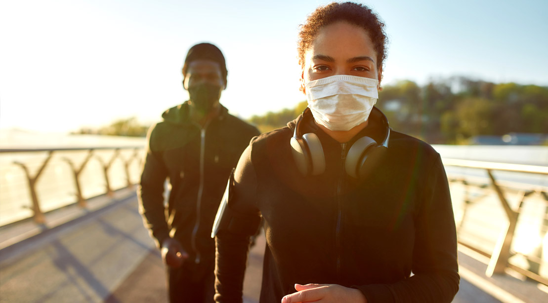 Couple running outdoors while wearing a face mask during the Covid-19 Pandemic
