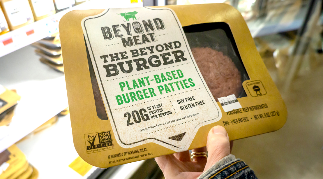 Person grocery shopping for Beyond Meat Beyond Burger