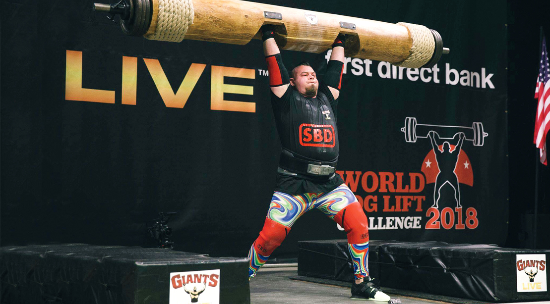 Strongman Rob Kearney lifting a heavy log at a strong man competition
