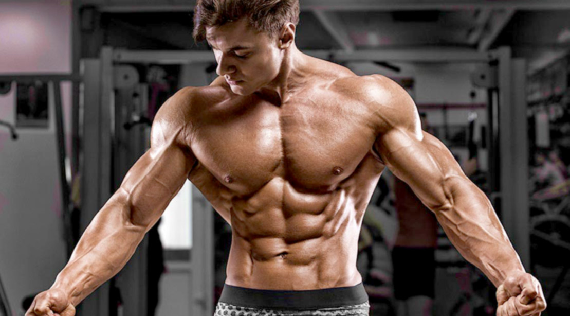 Muscular fitness model with a six pack and muscular forearms training with updated training principles