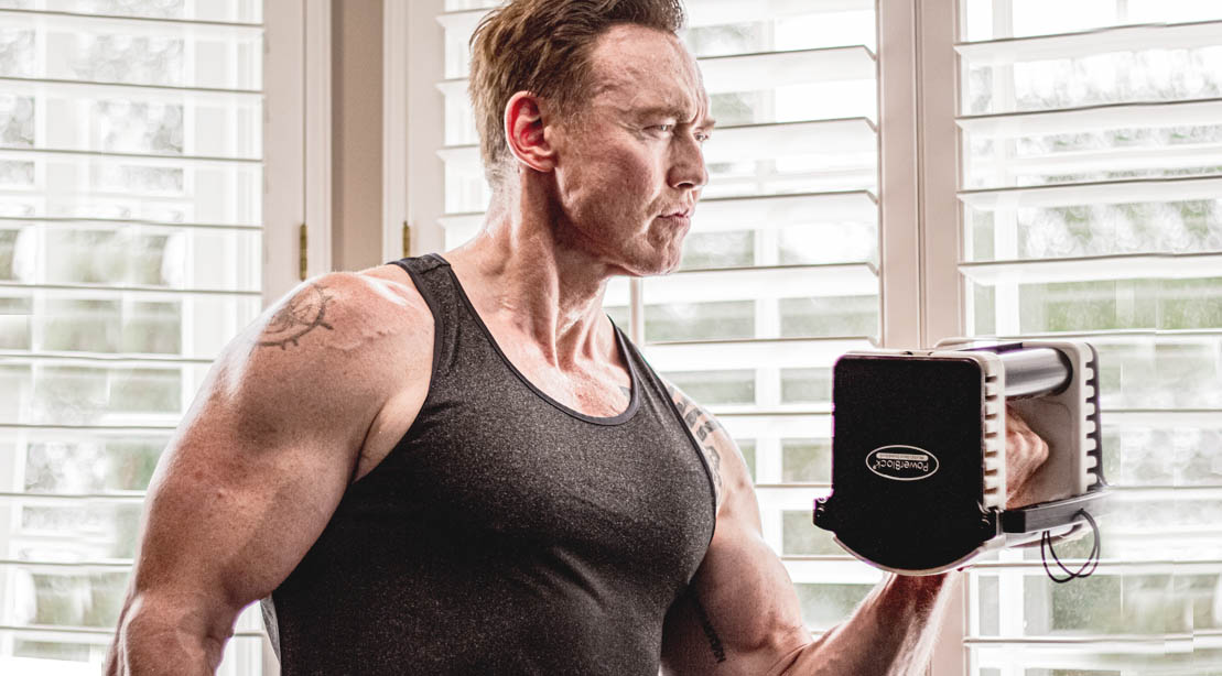 Actor Kevin Durand doing a bicep curl with a bowflex dumbbell