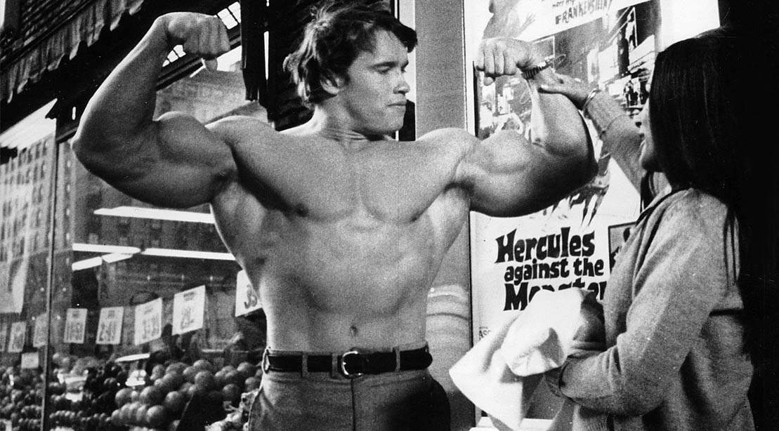 Young Arnold Schwarzenegger flexing his biceps