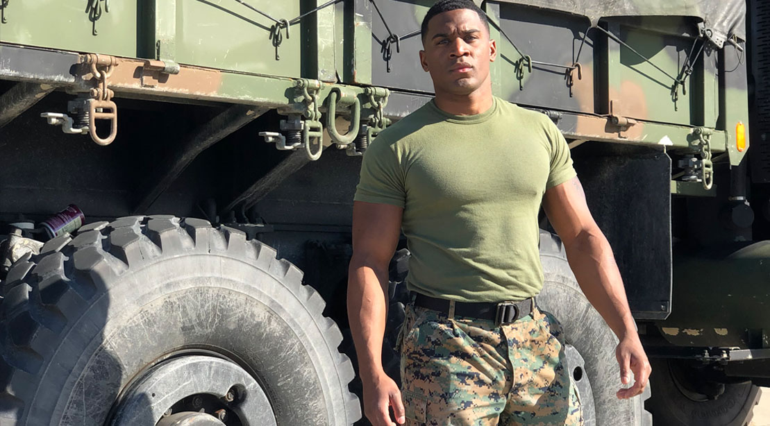 Aaron Marks Wearing Army Fatigues In Front of An Army Truck