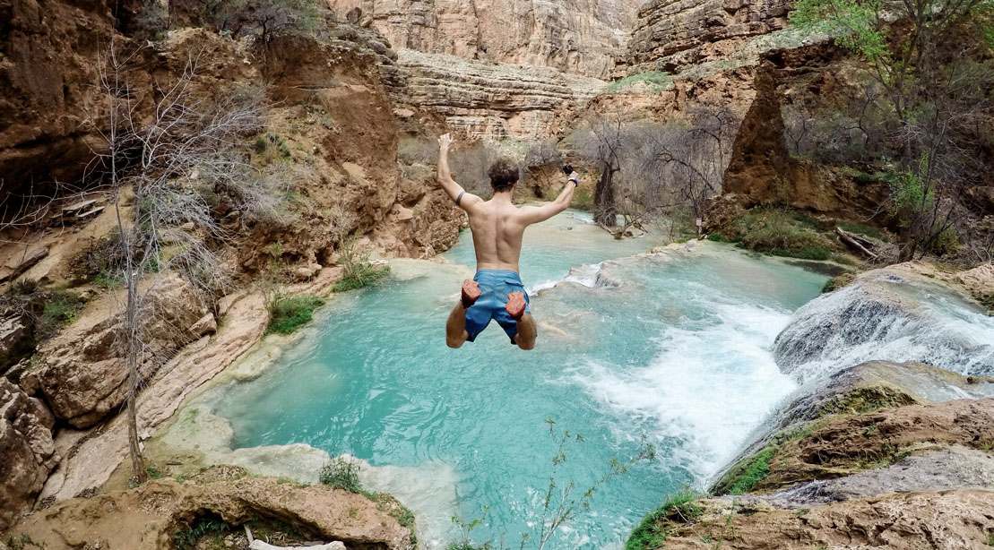 Man jumping down a waterfall as a summer activity
