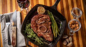 A cooked ribeye steak on a cast iron pan about to be cooked by the Star of Fowl Life Chad Belding