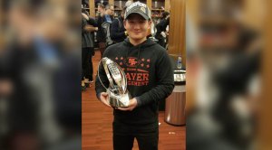 NFL trainer Tom Zhang holding the Superbowl trophy in the 49ers locker room