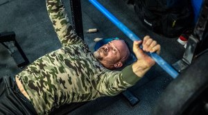 Berto Colón actor and star of Power Book II- Ghost performing an upper body workout using a barbell bench press exercise