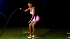 Female wrestler Brandi Rhodes working out with battle ropes exercise