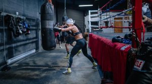 Female boxer Alycia Baumgardner training in the boxing gym hitting the heavy bag