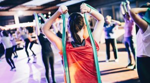 Group fitness class performing resistance band workouts