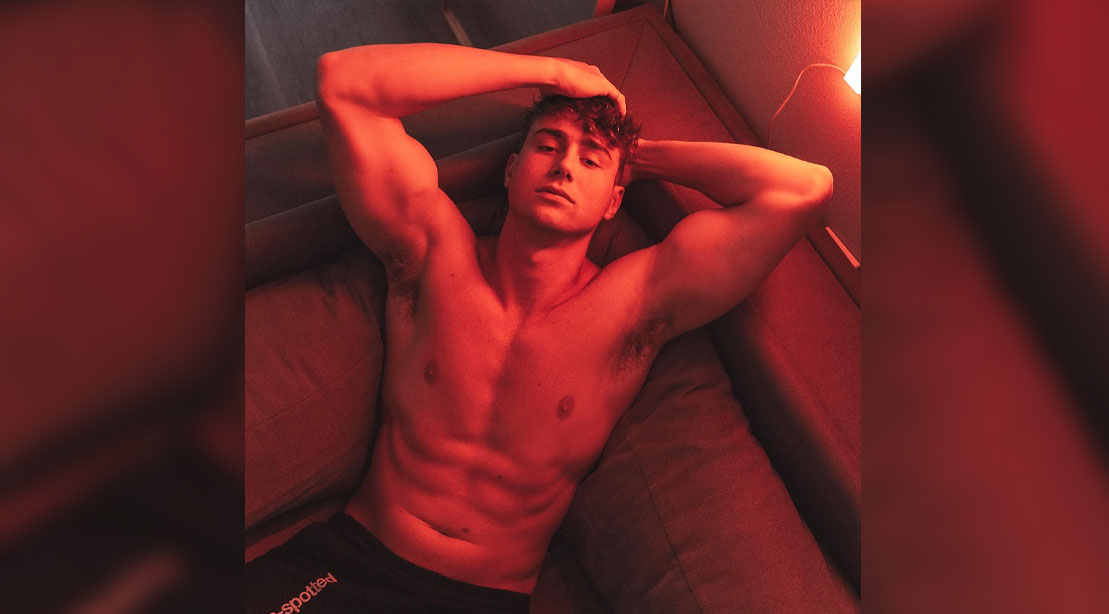 Harry Jowsey in a red light room showing his muscular physique