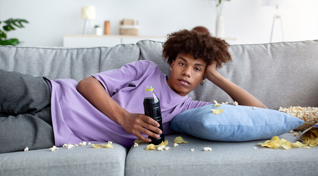 Black teen boy living a sedentary lifestyle with a sugary diet