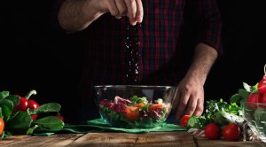 Chef creating and seasoning the perfect salad