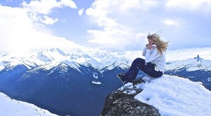 Skiier Jamie Crane-Mauzy sitting on a cliff ontop of a ski mountain