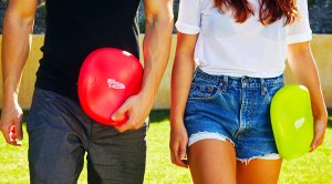 Fit couple playing outdoors with their wham-o frisbee