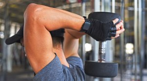 Man performing isolation exercises with an overhead tricep extension