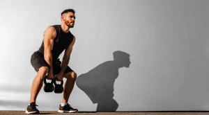 Muscular man performing a bodybuilding kettlebell workout