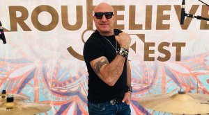 Musician Kenny Aronoff flexing his bicep muscles on the red carpet