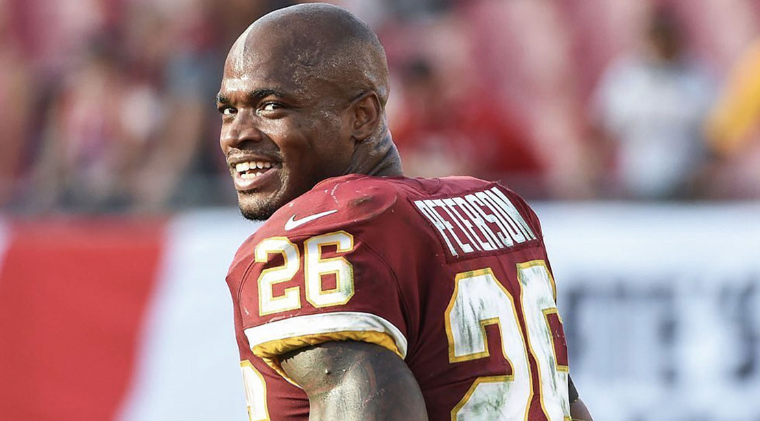 NFL Player Adrian Peterson smiling at the camera wearing a redskins uniform